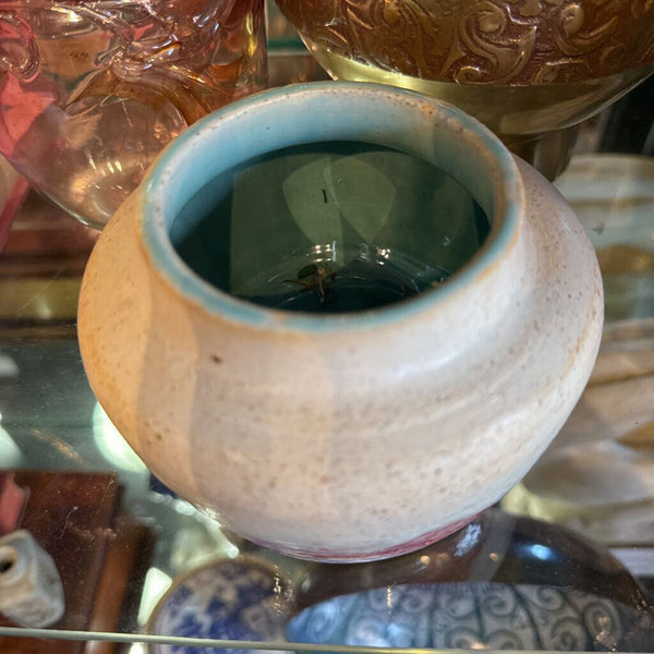Cream pottery bowl with pink and turquoise inside