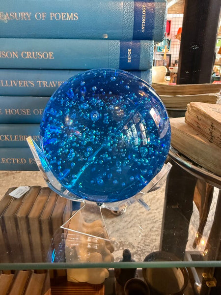Blue glass paperweight in stand