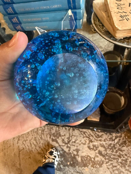 Blue glass paperweight in stand