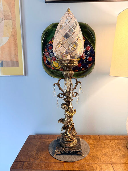 Vintage Hollywood Regency cherub table lamp featuring a diamond cut shade, prisms and a footed marble base. For pick up only approx 33t
