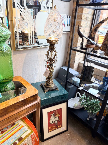 Vintage Hollywood Regency cherub table lamp featuring a diamond cut shade, prisms and a footed marble base. For pick up only approx 33t