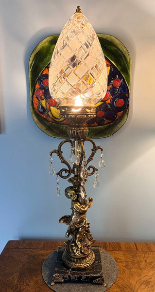 Vintage Hollywood Regency cherub table lamp featuring a diamond cut shade, prisms and a footed marble base. For pick up only approx 33t